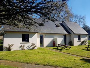 een wit huis met een picknicktafel ervoor bij Studios - Location de vacances Le Trécelin in Plévenon