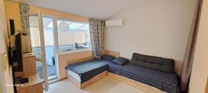 a living room with a couch and a window at DELUXE TOP CENTER House with garden's tent ,2 bedrooms and living room next to the BEACH and SEA GARDEN- 5 min by walk,with equiped kitchen in Burgas City