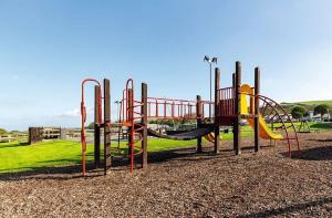 a playground with a slide in a park at HARRIES LODGE QUAY WEST milkwood way in New Quay