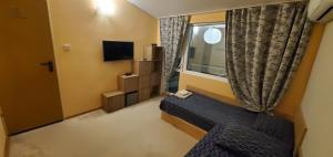 a small room with a bed and a window at DELUXE TOP CENTER House with garden's tent ,2 bedrooms and living room next to the BEACH and SEA GARDEN- 5 min by walk,with equiped kitchen in Burgas City