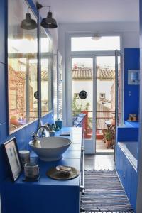 uma casa de banho com um lavatório e uma parede azul em La Maison d'Elysa em Perpignan