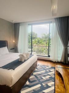 楠府的住宿－Villa Mahaphrom，一间卧室设有一张床和一个大窗户