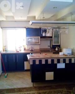 uma cozinha com armários azuis e uma bancada em دوبلكس مفروش ومجهز em Sharm el Sheikh