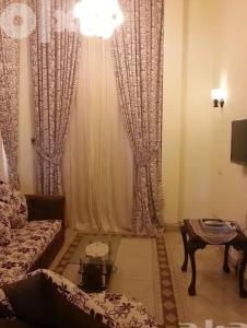 uma sala de estar com um sofá, uma mesa e cortinas em دوبلكس مفروش ومجهز em Sharm el Sheikh
