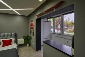 a bedroom with a bed and a large window at Modern Studio Escape in Timişoara