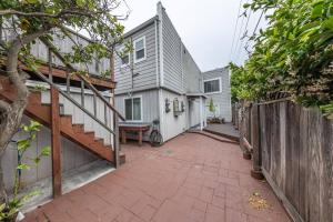 a house with a brick walkway next to a fence at Quiet Home Near SFO with Backyard / BBQ in San Bruno