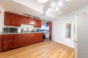 a kitchen with wooden cabinets and a hardwood floor at Quiet Home Near SFO with Backyard / BBQ in San Bruno