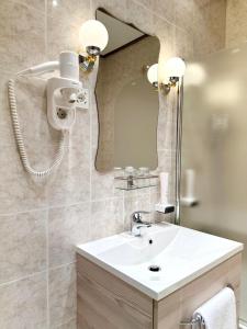 y baño con lavabo blanco y espejo. en Éllő Residence, en Veszprém