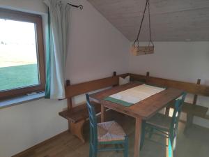 einen Tisch und Stühle in einem Zimmer mit Fenster in der Unterkunft Ferienwohnung auf dem Land in Tuntenhausen