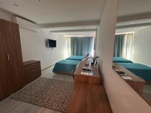 a hotel room with two beds and a desk in it at La Bella Guesthouse in St. Julianʼs
