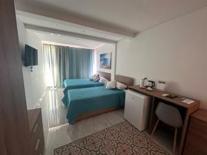 a bedroom with a bed and a desk and a window at La Bella Guesthouse in St. Julianʼs