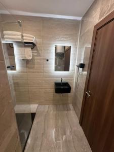 a small bathroom with a sink and a mirror at La Bella Guesthouse in St. Julianʼs