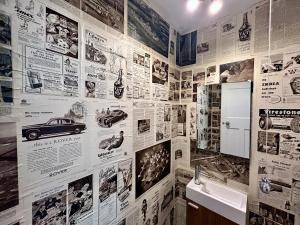 a bathroom with a wall covered in posters and a sink at Palm - Bournemouth in Bournemouth