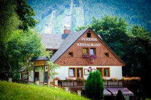 a house with a sign that reads vygian restaurant at Pension & Restaurant Krakonoš in Harrachov