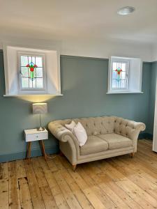 a living room with a couch and two windows at Palm - Bournemouth in Bournemouth