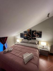 een slaapkamer met een groot bed en 2 handdoeken bij beb dragonara apartment in Torre Maggiore