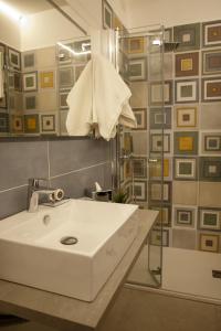 a bathroom with a sink and a shower with a mirror at Alba in Centro in Lampedusa +17 photos