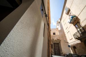 a narrow alley with a building and a balcony at B&B Cantiere dell'anima - Rooms of art in Trapani