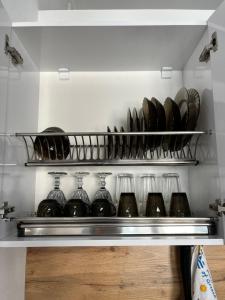 un estante lleno de vasos y platos en una cocina en Апартаменты Tropicana, en Samarkand