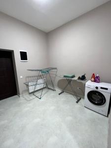 lavadero con lavadora y mesa en Апартаменты Tropicana, en Samarkand