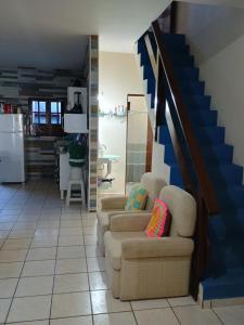 ein Wohnzimmer mit 2 Stühlen und einer Treppe in der Unterkunft Recantotabuba in Barra de Santo Antônio
