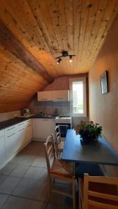 een keuken met een houten plafond met een tafel en stoelen bij etang de la bibardiere in Allonnes