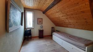 een slaapkamer met een bed in een kamer met een houten plafond bij etang de la bibardiere in Allonnes