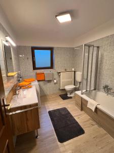 uma casa de banho com um lavatório, uma banheira e um WC. em Ferienwohnung Strohmeyer em Oberaudorf