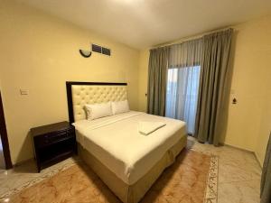 a bedroom with a large bed and a window at Safari Hotel Apartments in Ajman  +13 photos
