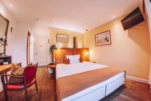 a bedroom with a bed and a desk and a chair at Hotel Zum Ochsen in Oberstenfeld