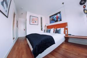 Schlafzimmer mit einem großen weißen Bett und Holzböden in der Unterkunft Hotel Zum Ochsen in Oberstenfeld