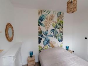 a bedroom with a bed with a tropical wallpaper at Appartement 50m² centre-ville in Dunkerque