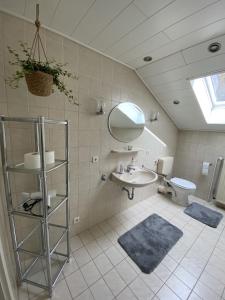 ein Badezimmer mit einem Waschbecken, einem Spiegel und einem WC in der Unterkunft Zur schönen Aussicht in Bad Wildungen