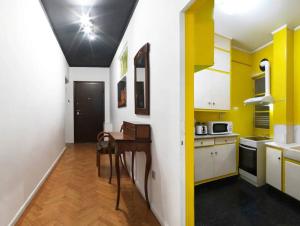 アテネにあるHestia Anemone - Spacious Apartment in Kolonakiのキッチン(黄色と白のキャビネット、テーブル付)