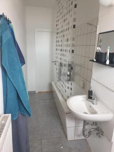 a white bathroom with a sink and a tub at Ferienwohnung ErzHome in Marienberg