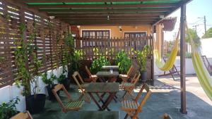 un patio con sillas, mesa y columpios en Villaggio dos Ventos, en Arraial do Cabo