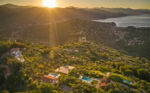 an aerial view of a city with the sun setting on a mountain at Il Leccio - Luxury Resort Portofino Monte in Santa Margherita Ligure