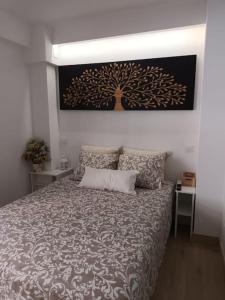 a bedroom with a bed with a tree picture on the wall at A&a MADRID in Madrid