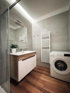 a bathroom with a sink and a washing machine at Apartment Kino in Ljubljana
