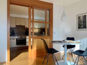 een keuken met een tafel en stoelen in een kamer bij Ferienwohnung mit Bergblick in Frastanz