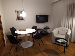een woonkamer met een tafel en stoelen en een televisie bij Ferienwohnung mit Bergblick in Frastanz