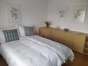 Schlafzimmer mit einem großen weißen Bett und Schränken in der Unterkunft Ferienwohnung mit Bergblick in Frastanz