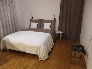 een slaapkamer met een groot bed en een houten vloer bij Ferienwohnung mit Bergblick in Frastanz