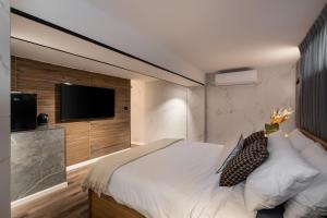 a bedroom with a large bed and a flat screen tv at Mulan Hotel in Tel Aviv