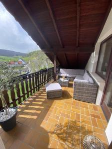 einen Balkon mit Sofas und Stühlen auf dem Dach in der Unterkunft Zur schönen Aussicht in Bad Wildungen