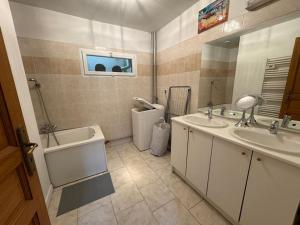 Le Clos de Jade - Maison individuelle - 3 chambres في نمور: حمام به مغسلتين وحوض استحمام ومرآة