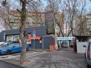 een parkeerplaats met auto's geparkeerd voor een winkel bij Sunny 2-Bedroom Maisonette Varna & Parking in Varna