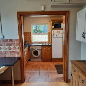 a kitchen with a washer and dryer in it at Cheerful three bedroom country cottage in Ballina