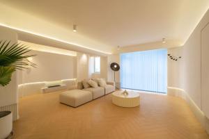 上海Moli B&B - Bund River View Near Yu Garden subway 3bedrooms 2bathrooms 1bathtube with elevator apart ment的客厅里有一张白色的沙发和一张桌子
