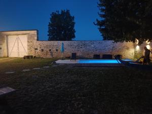 a backyard with a swimming pool at night at Moulin de Bellicout in Charmé